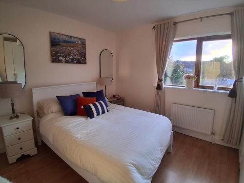 a bedroom with a large white bed with a window at Haven Dungarvan in Dungarvan