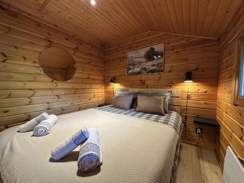 a bedroom with a bed in a wooden cabin at Chalet du Grand Arbre in Le Ménil