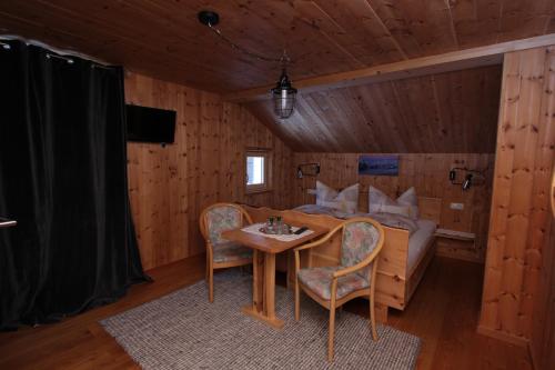 a bedroom with a bed and a table and chairs at Haus am Rain in Partenen