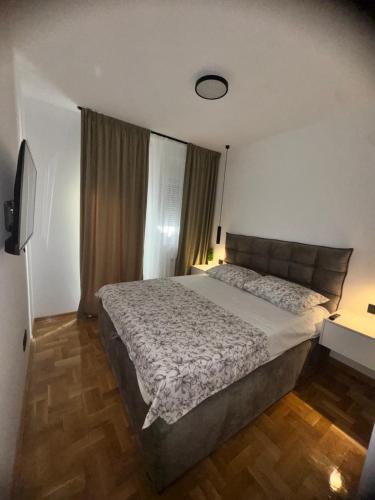 a bedroom with a large bed and a window at Fairy tale apartment 9 in Voždovac