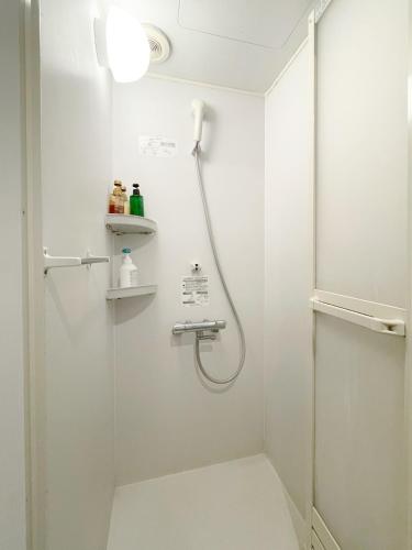 a shower in a bathroom with a glass door at Arcade Resort Okinawa in Okinawa City