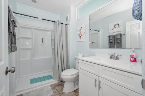 a white bathroom with a shower and a toilet at Park Place Unit 129 in Cedar Key