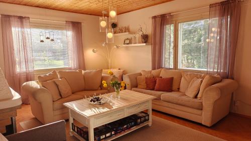 a living room with two couches and a coffee table at Peaceful house for relaxing in Oulu