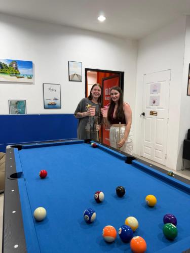 Ban Khlong HaengにあるGlobal Beach Hostel - Ao Nangの二人の女性がビリヤード台の横に立っている