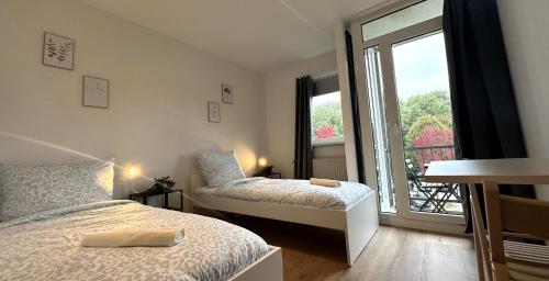 a bedroom with two beds and a window at Business Apartment with Balcony in Osnabrück
