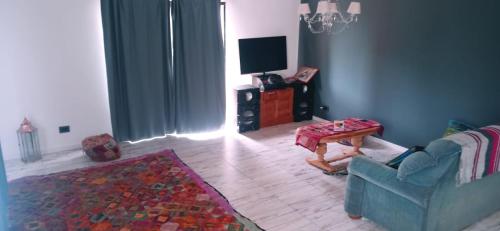 un salon avec un canapé bleu et une table dans l'établissement Las Golondrinas, à Veinticinco de Mayo