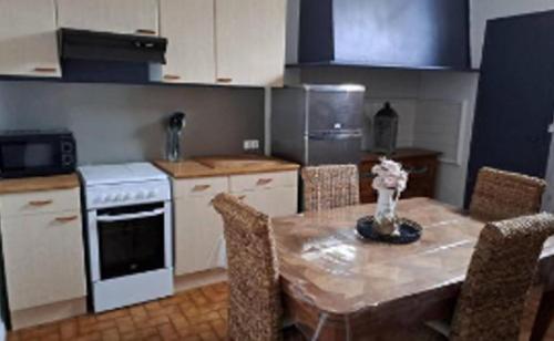 Villa Thomas في أركاشون: مطبخ به طاولة وكراسي وموقد