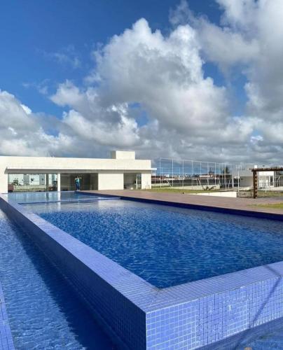 a large swimming pool in front of a building at Apartamento completo proximo as Praias do Litoral Sul in João Pessoa