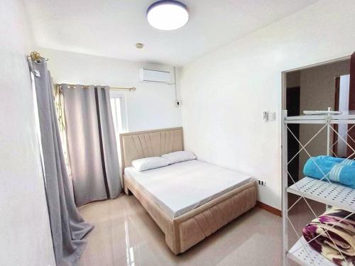 Dormitorio pequeño con cama y estante en MJs Residence, en General Santos
