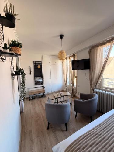 ein Wohnzimmer mit zwei Stühlen und einer Couch in der Unterkunft Studio dans le cœur de Mulhouse in Mulhouse