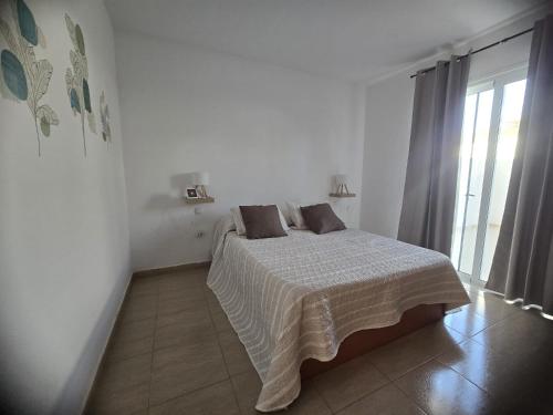 una camera bianca con un letto con due cuscini di Las Dos Orillas a Costa Calma