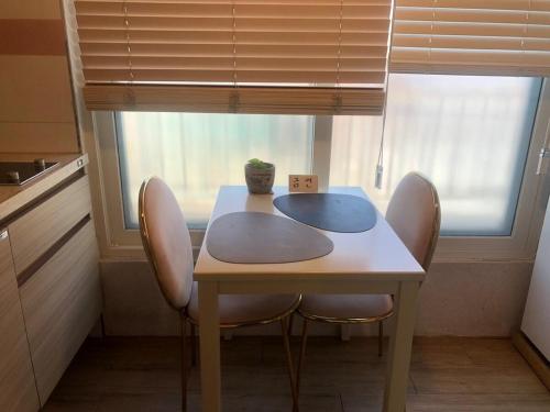 a table and chairs in a kitchen with a window at gd house! in Hyoja-dong
