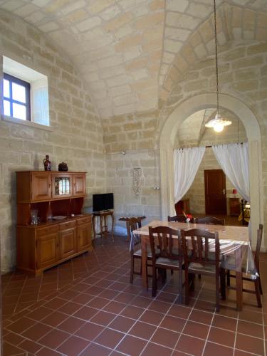 a dining room with a table and chairs in a room at Masseria Montanari in Carpignano Salentino