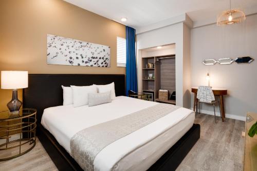 a bedroom with a large white bed and a desk at Catalina Hotel & Beach Club in Miami Beach