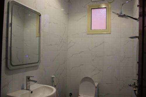 a bathroom with a sink and a toilet and a window at شاليه التميز الراقي - الهدا in Taif