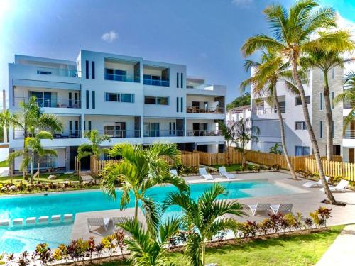 an image of a resort with a swimming pool and palm trees at Modern apartament near the sea-Las Terrenas in La Iglesia