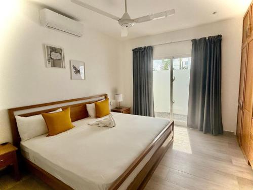 a bedroom with a large bed with yellow pillows at Modern apartament near the sea-Las Terrenas in La Iglesia