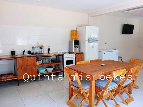 a kitchen with a wooden table and a refrigerator at Casaquinta MISPEKES in La Reja