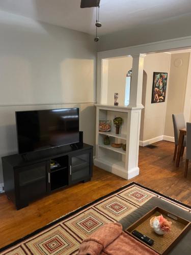 a living room with a large flat screen tv at Private downtown cottage in Indianapolis