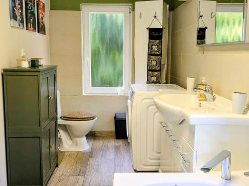 a bathroom with a sink and a toilet and a window at Sonnenterrasse & 2 King-Size DZ - Citynah & ruhig in Berlin