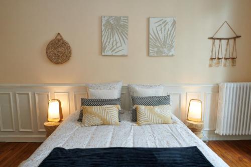 Un dormitorio con una cama con almohadas y dos lámparas. en Hyper centre 2 chambres cosy 70m2, en Reims