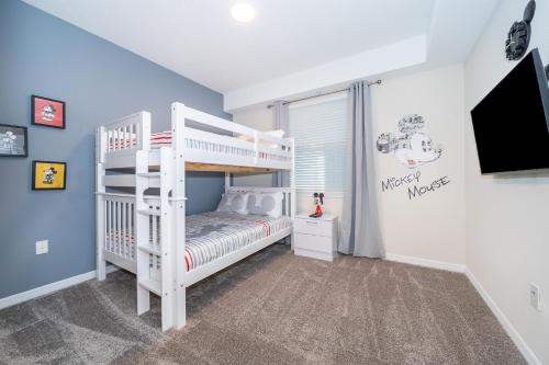 a white bunk bed in a room with a tv at 3171-204AZ STOREY LAKE, CONDO 2/2 LAKE VIEW in Kissimmee