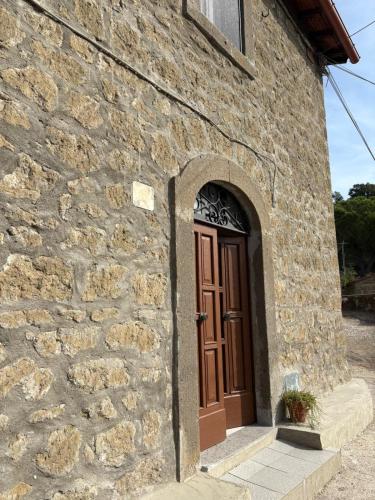 a brick building with a wooden door on it at Le coste sul lago in Montefiascone