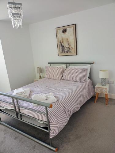 a bedroom with a large bed with striped sheets at Luxury 2-Bed Flat Central Ipswich Parking in Ipswich