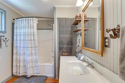 a bathroom with a tub and a sink and a mirror at Mossy Creek Cabin in Cleveland