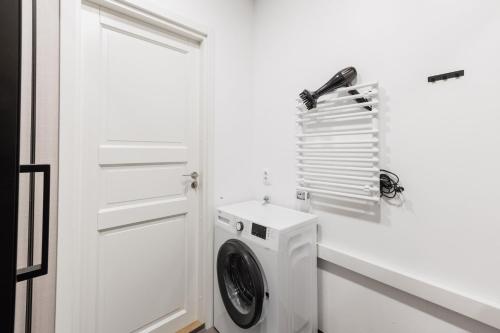 a white laundry room with a washing machine at Modern studio in Siena Tirgus in Rīga