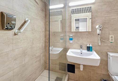 a bathroom with a sink and a glass shower at Slina Hotel Brussels in Brussels