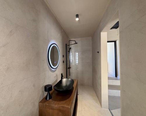 a bathroom with a sink and a mirror on the wall at Alfa25 in Oitylo