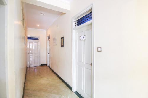 a hallway with white walls and a door at Hotel O Kingston Residency in Vānivilāsa Puram