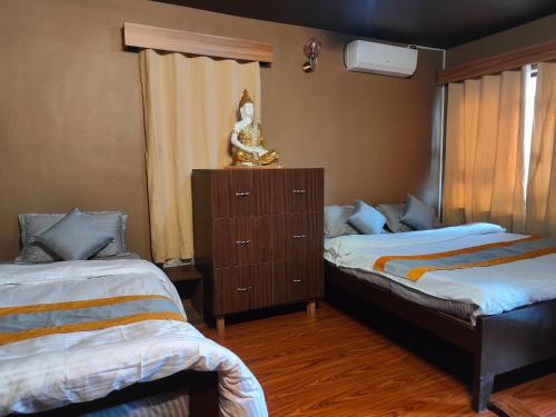 Un dormitorio con dos camas y una cómoda. en Nepal Blissful Nest And Family Home, en Katmandú