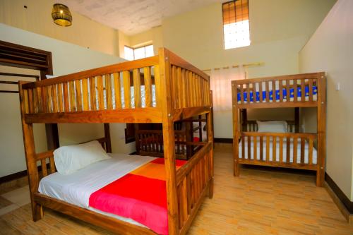 two wooden bunk beds in a room with at Hotel Acacia View in Kampala