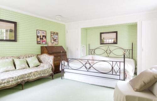 a bedroom with a bed and a couch at Charmant manoir Sud de Paris in Saint-Sauveur-sur-École