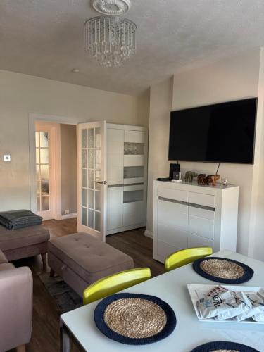 a living room with a table and a tv at City break in Edinburgh