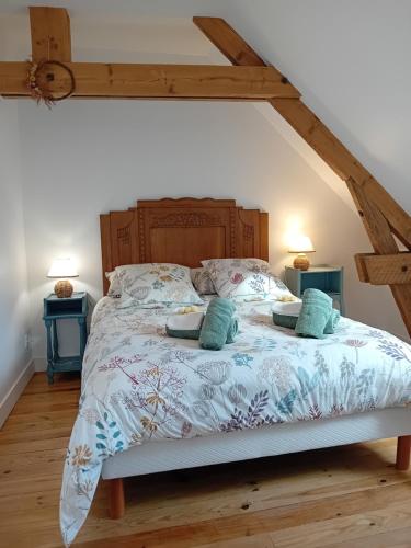 une chambre avec un grand lit avec une tête de lit en bois dans l'établissement Gite La Bignone, à Saint-Marcouf