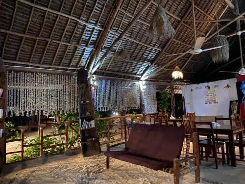 a room with a chair and a table in it at Mpole Bungalows in Michamvi