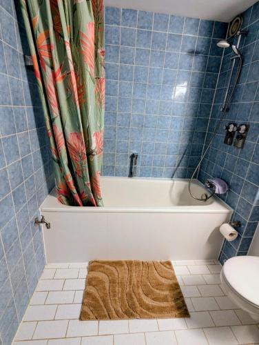 ein Badezimmer mit Badewanne und Duschvorhang in der Unterkunft MiMo 24 in Köln
