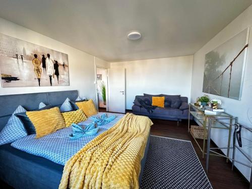 a bedroom with a blue bed and a couch at Modern Lakeview Apartment in Romanshorn