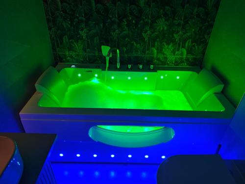 a green bathroom with a green tub with blue lights at Galway Paradisus in Galway