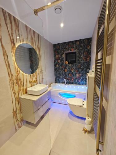 a bathroom with a tub and a sink and a mirror at Galway Paradisus in Galway