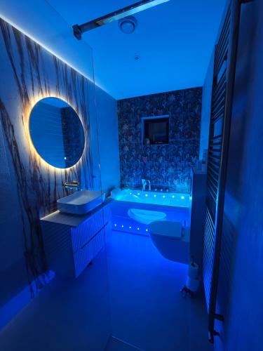 a blue bathroom with a tub and a sink at Ashwood Stay in Galway