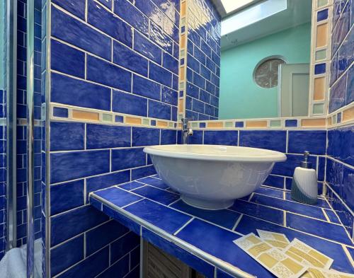 a blue tiled bathroom with a white sink at LA MAISON DU PORT - Superior Apartment, bright, glam, and refined with a wonderful sea view in Anzio city center in Anzio