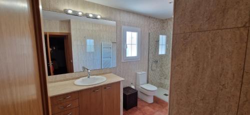 a bathroom with a sink and a toilet and a mirror at Finca Ca Nostra, Charmante Villa, Großzügiger Pool & Meerblick in Llucmajor