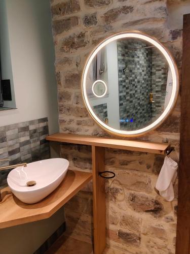 a bathroom with a sink and a mirror at Gîte du Volcan des Causses in Saint-Jean-dʼAlcapiès