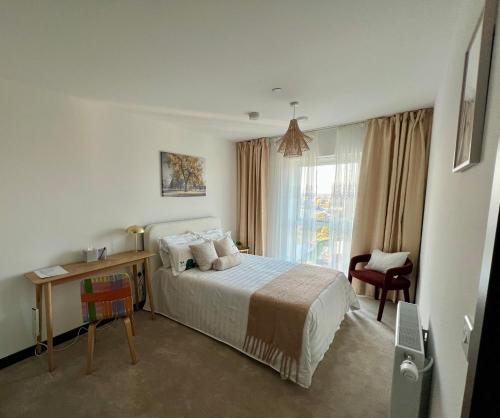 Un dormitorio con una cama y un escritorio y una ventana. en Luxury Double Bed En-Suite in London, en Barking