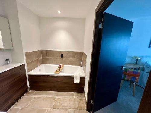 Un baño con bañera en una habitación. en Luxury Double Bed En-Suite in London, en Barking