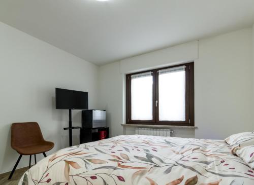 a bedroom with a bed and a chair and a window at Sonia Holiday Home - Camera Susan in Pont-Saint-Martin